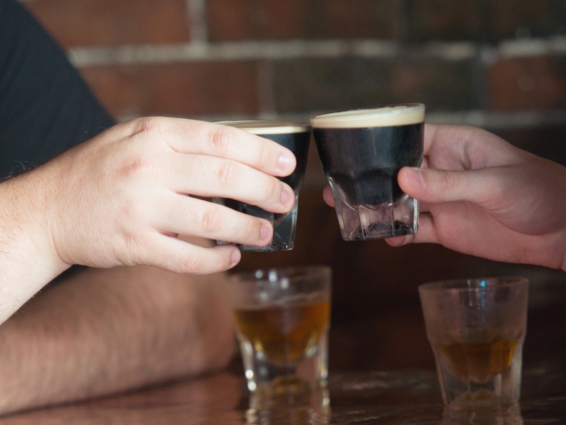 two people toast with glasses of beer