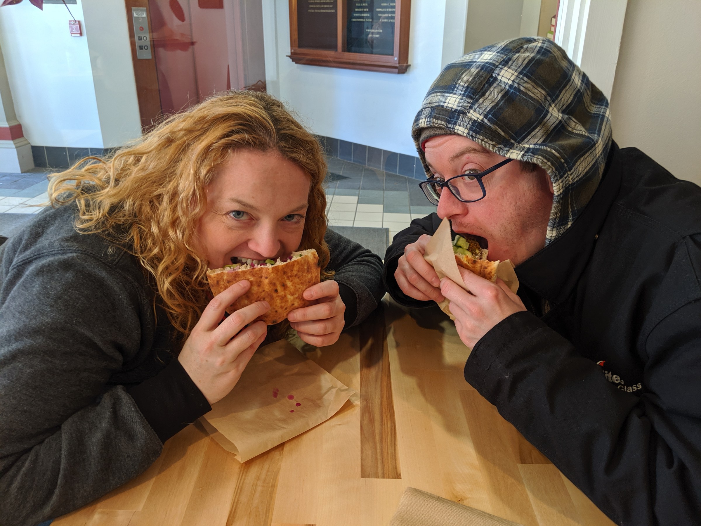 a man and a woman eating a sandwich