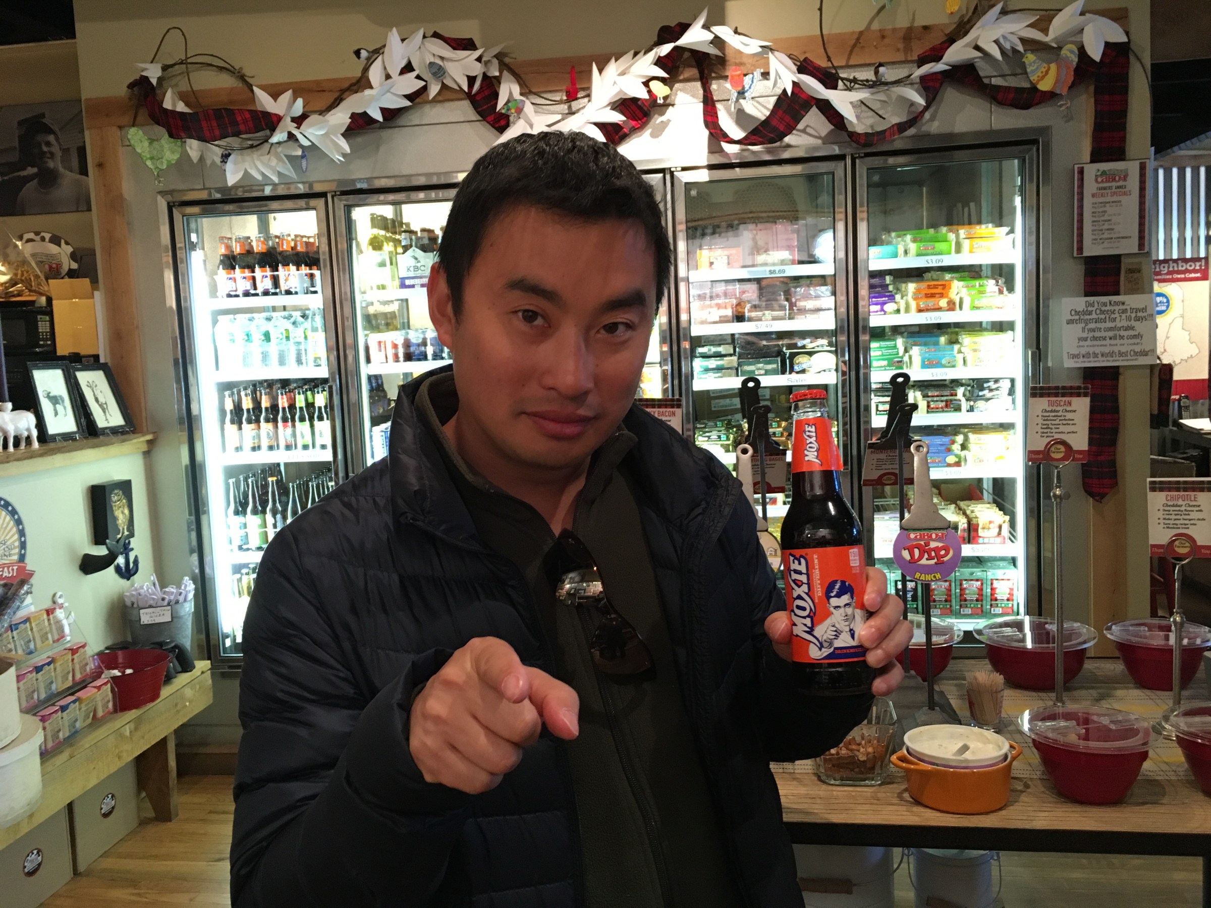 a person standing in a store holding a bottle of soda