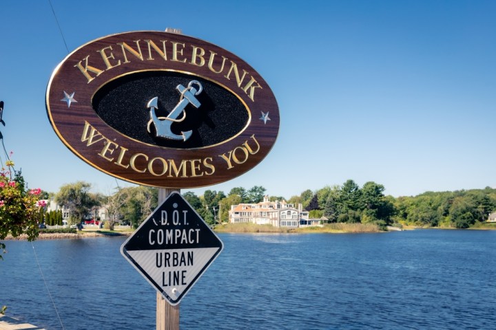 a sign in front of a lake