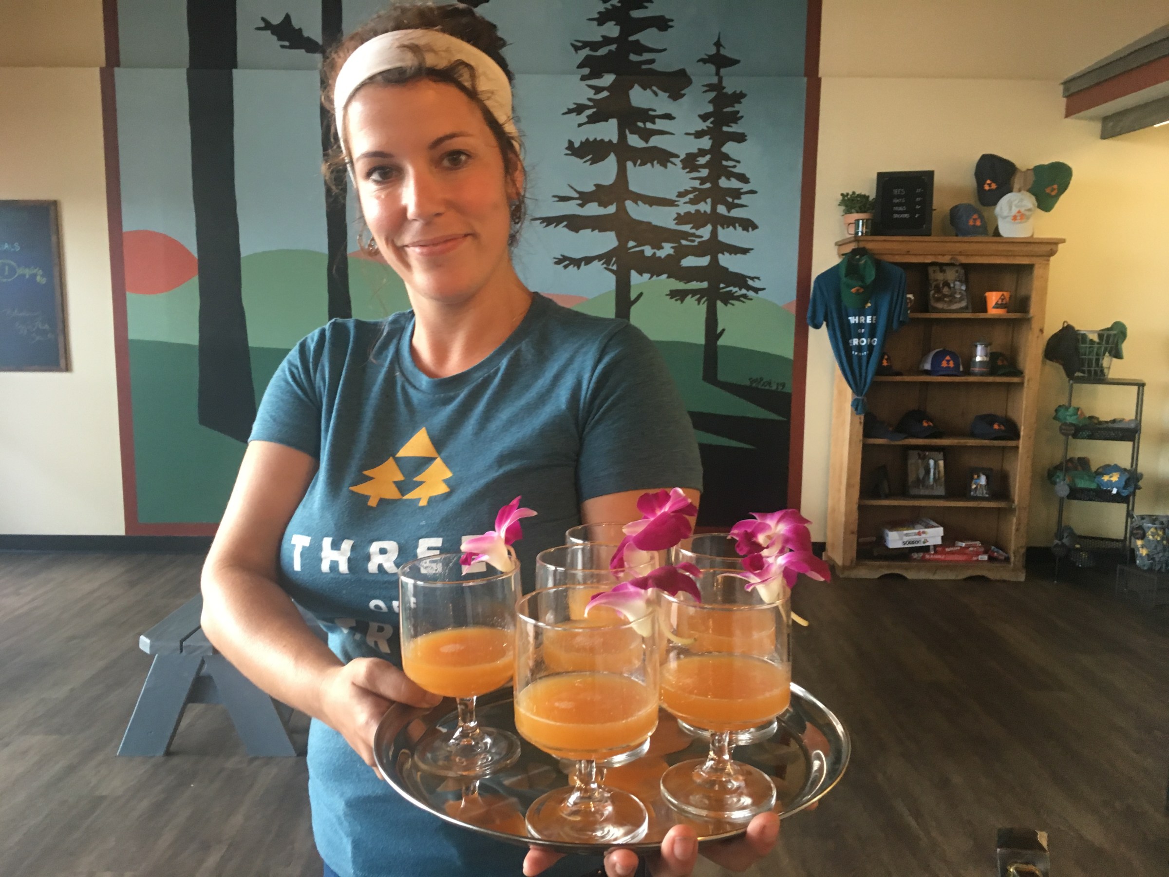 a woman bartender serving cocktails to a tour group