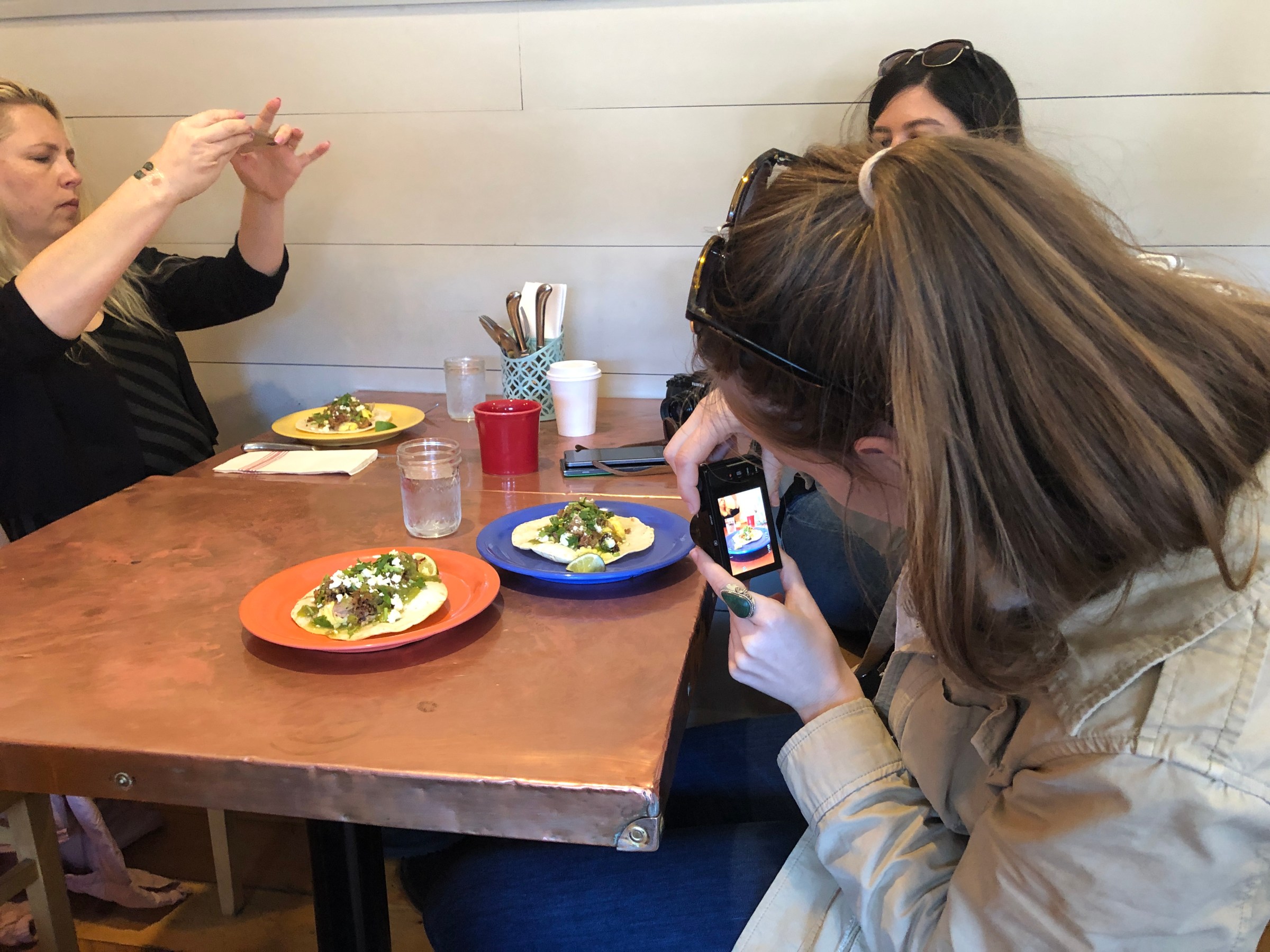 a group of people taking pictures of their food
