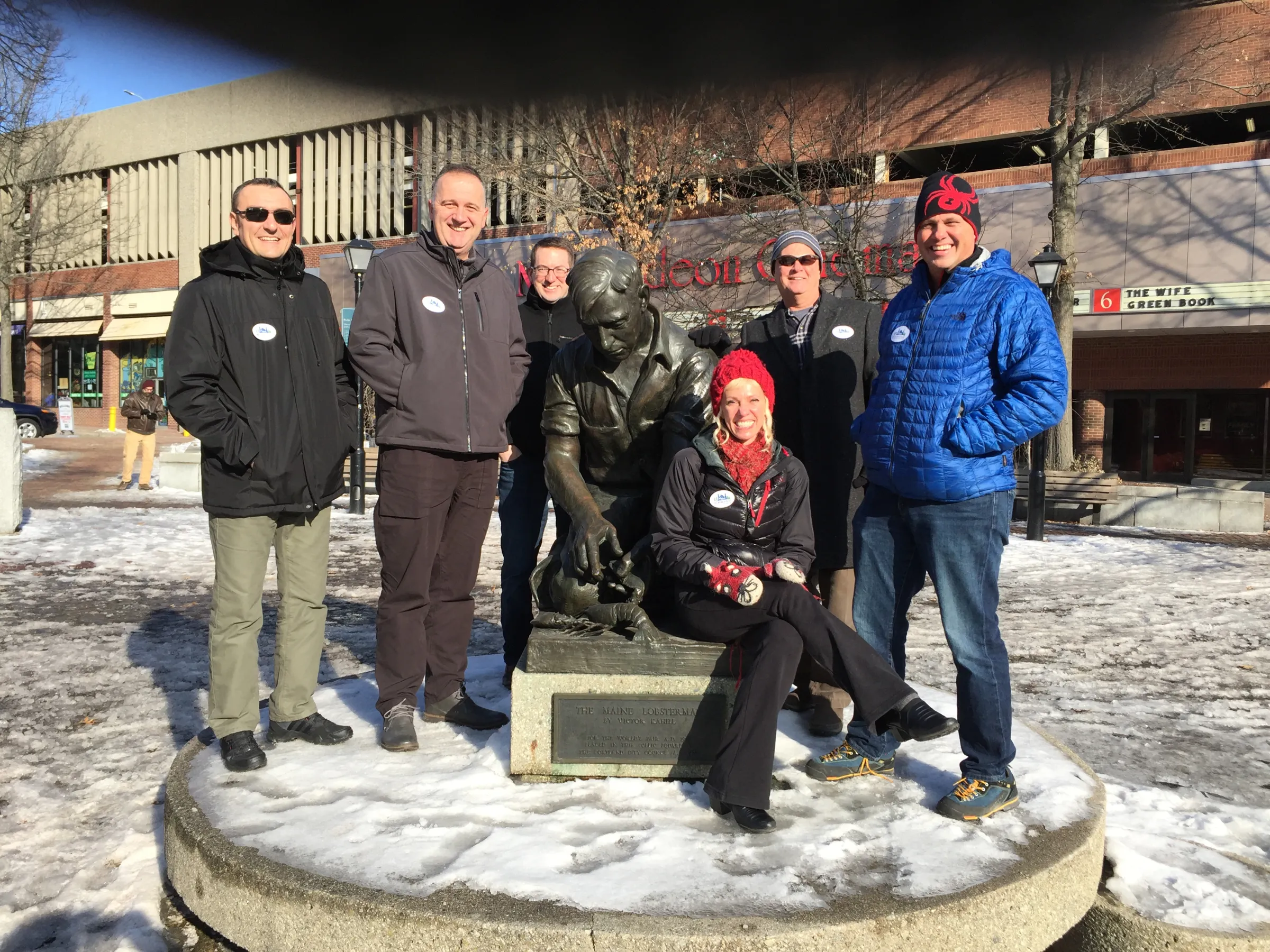 a group of people standing in front of a statue for a photo