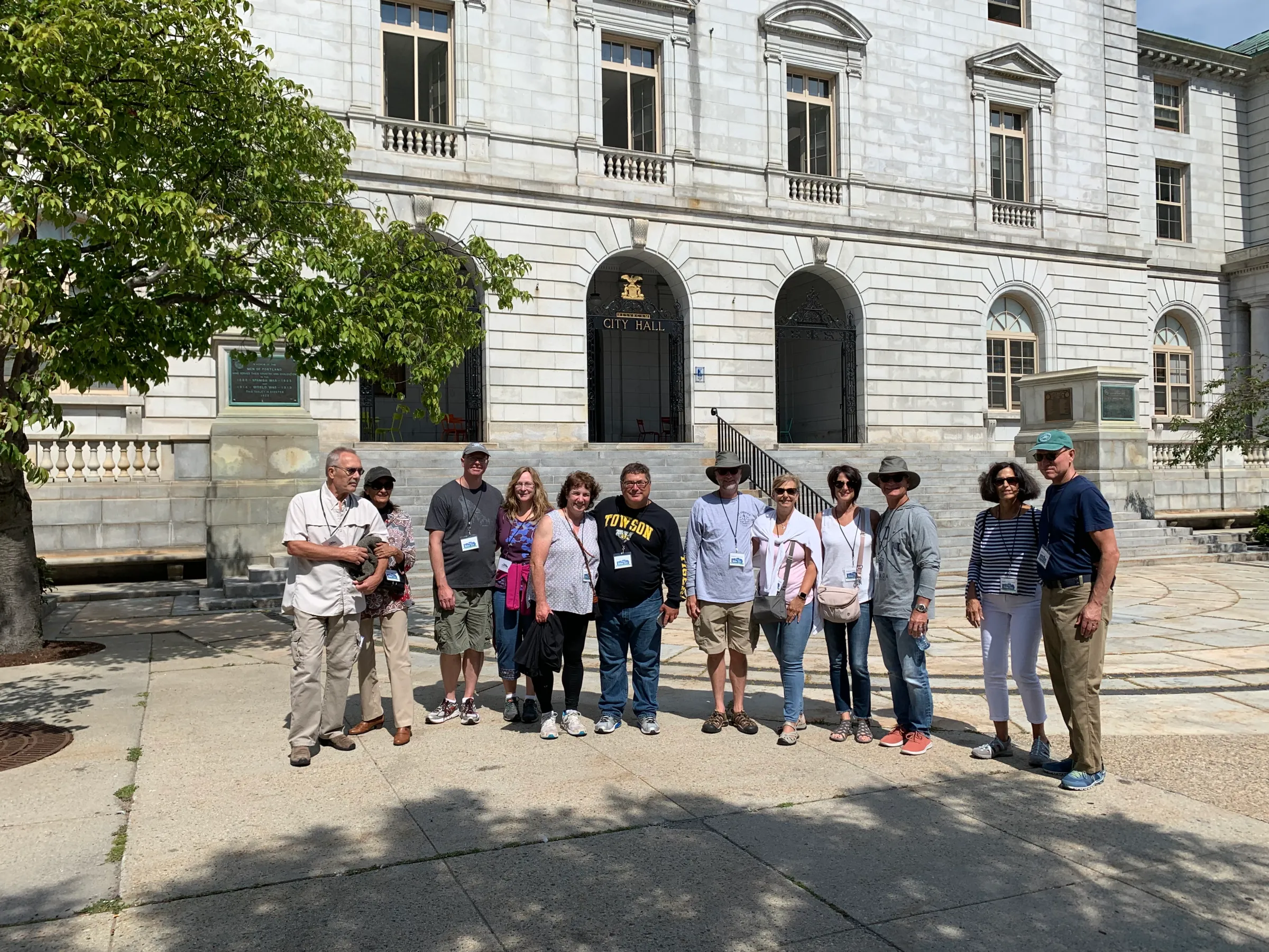 group of people posing for a photo in front of a granite buidling