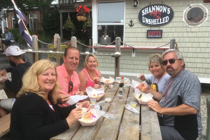 a group of people sitting at a table with food