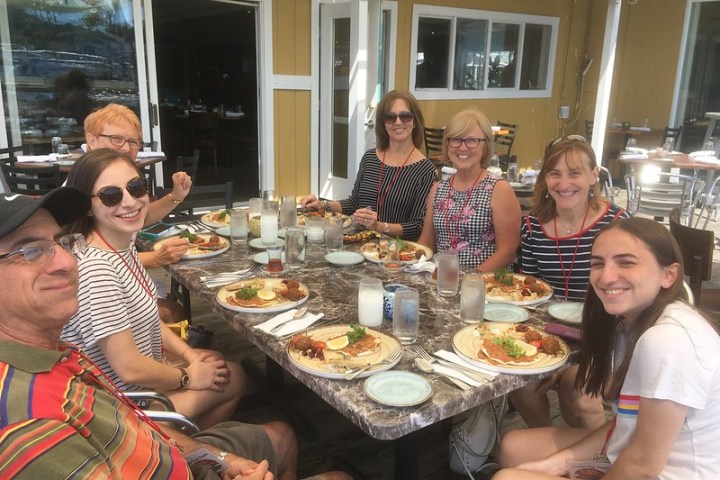a group of people sitting at a table with food