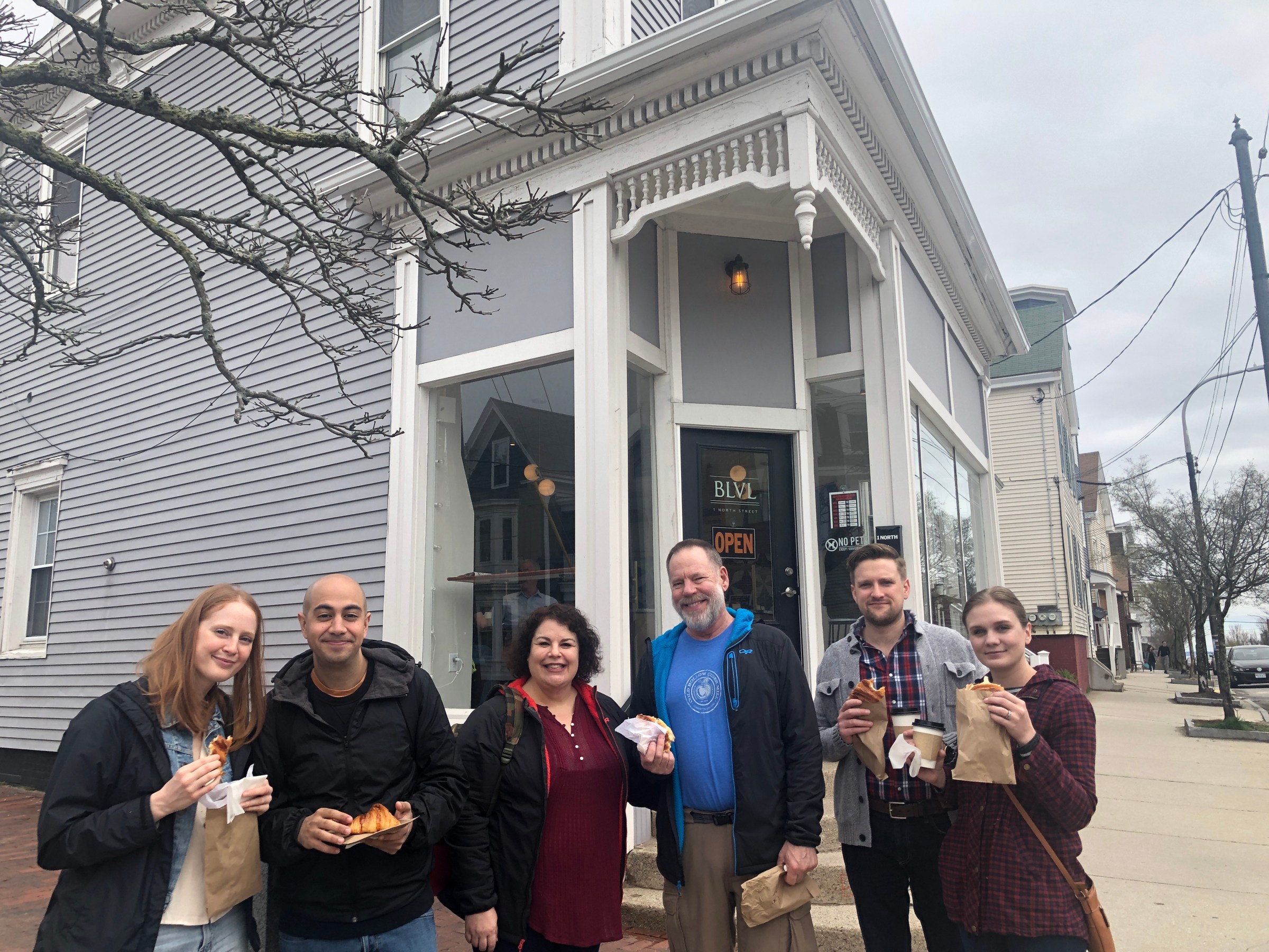 a group of people standing in front of a bakery