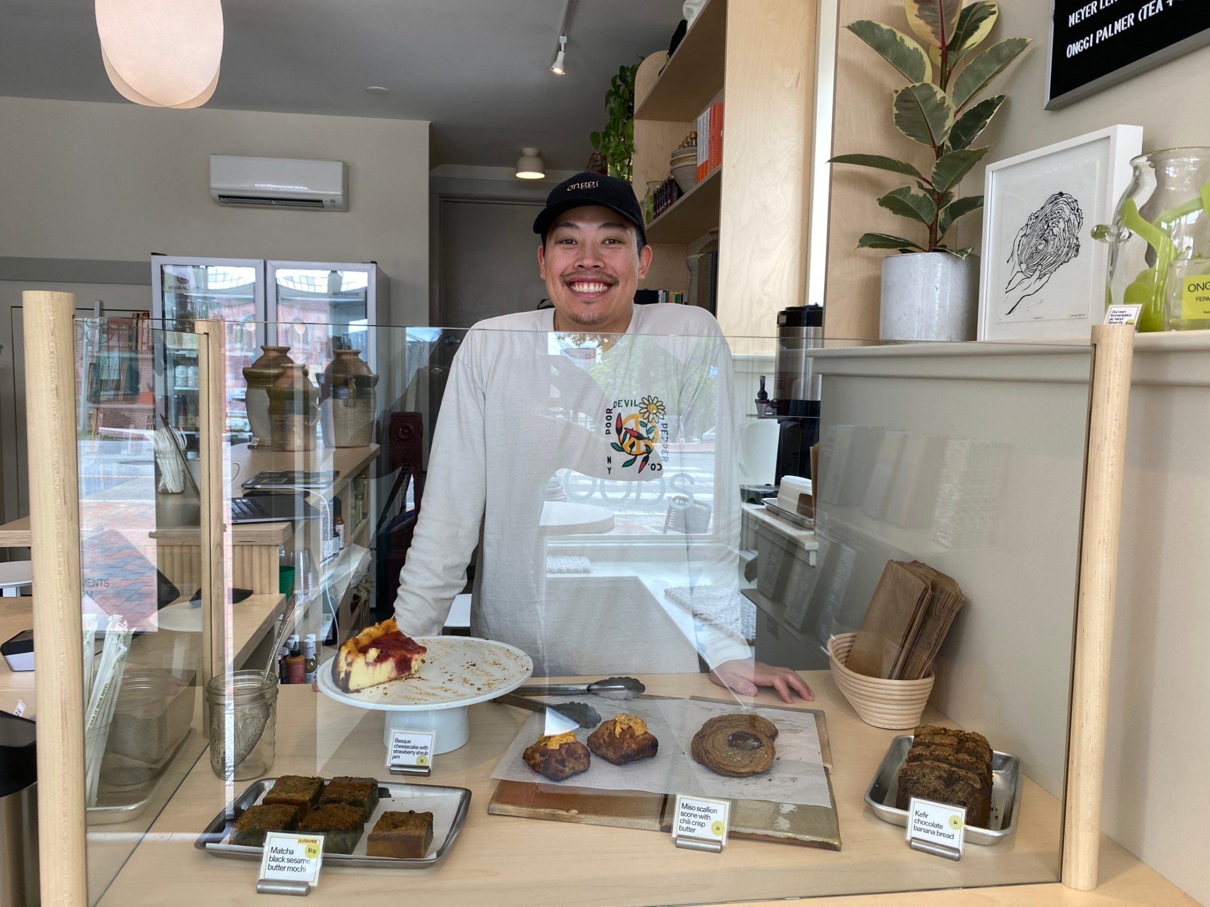 a person holding a donut in front of a store