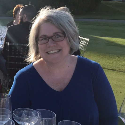 a woman sitting at a table with wine glasses