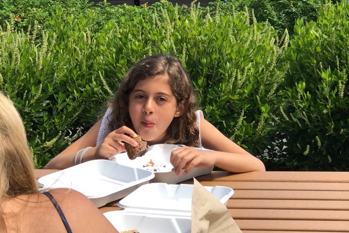 a woman sitting on a bench reading a book