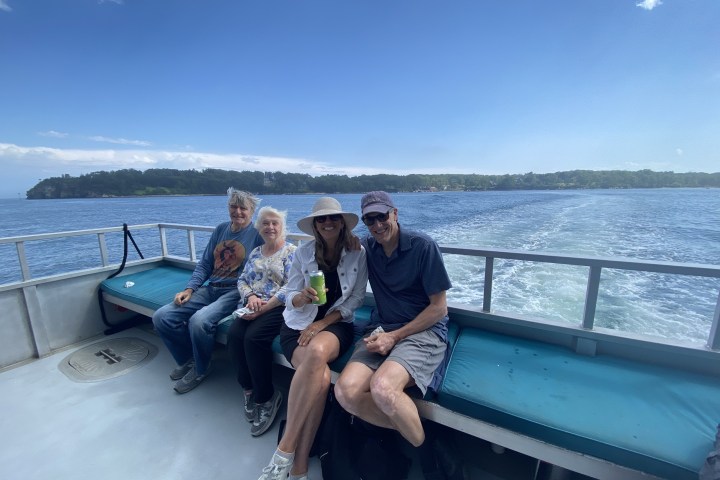 a person sitting on a bench next to a body of water