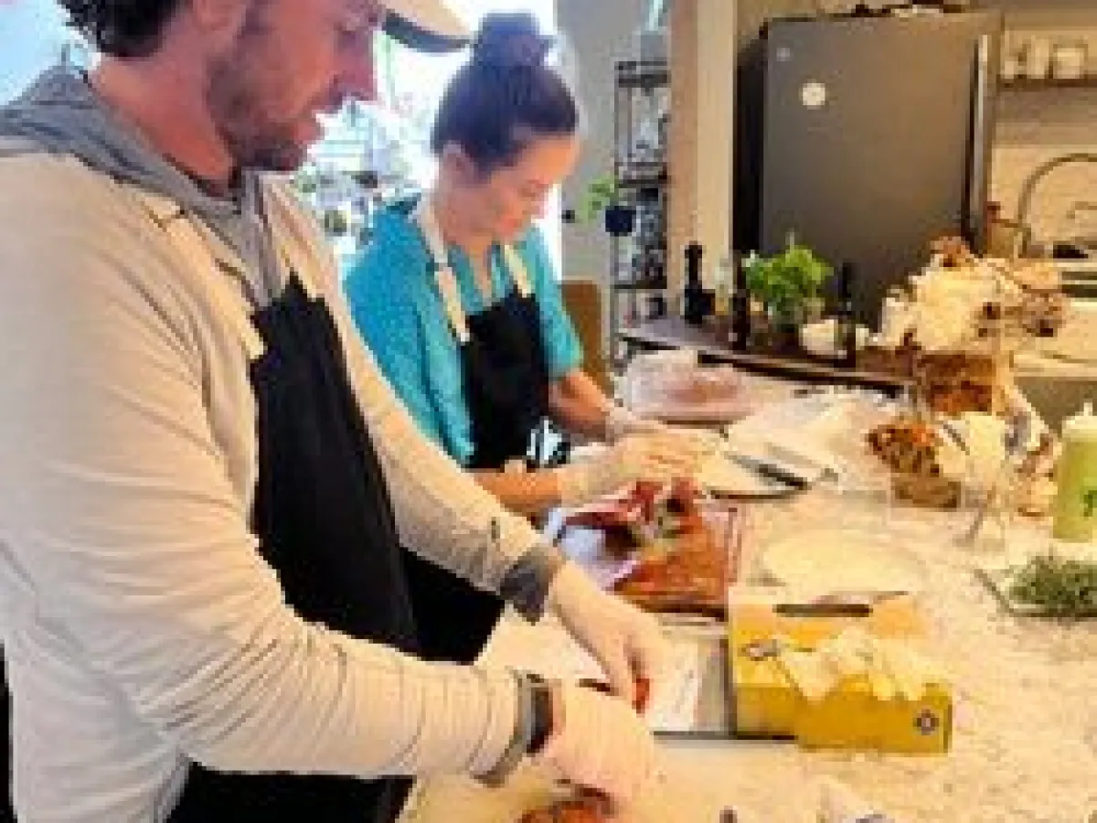 a man and woman preparing food in a kitchen