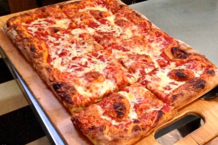 a pizza sitting on top of a wooden table