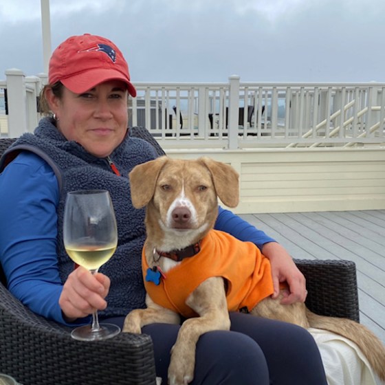 a man and a woman sitting on a bench with a dog