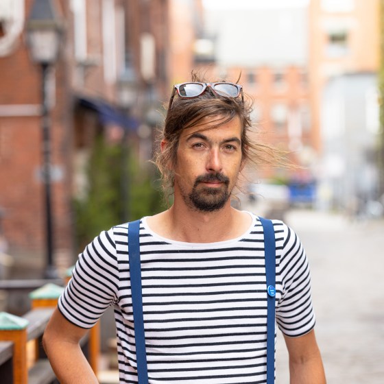 a person in a striped shirt in front of a building