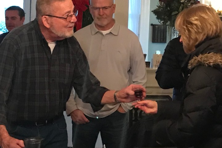 a group of people standing next to a glass of wine