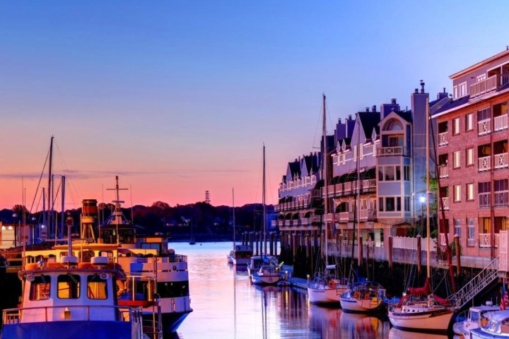 a small boat in a body of water with a city in the background