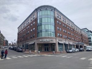 a group of people walking down a street in front of a building