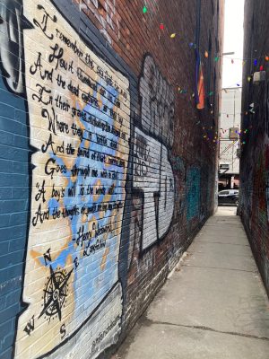 a building with graffiti on the side of a sidewalk