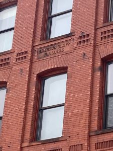 a tall brown brick building next to a window