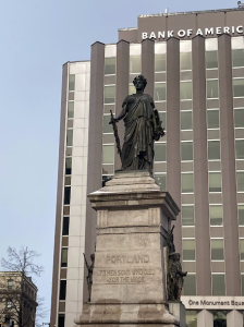a statue in front of a tall building