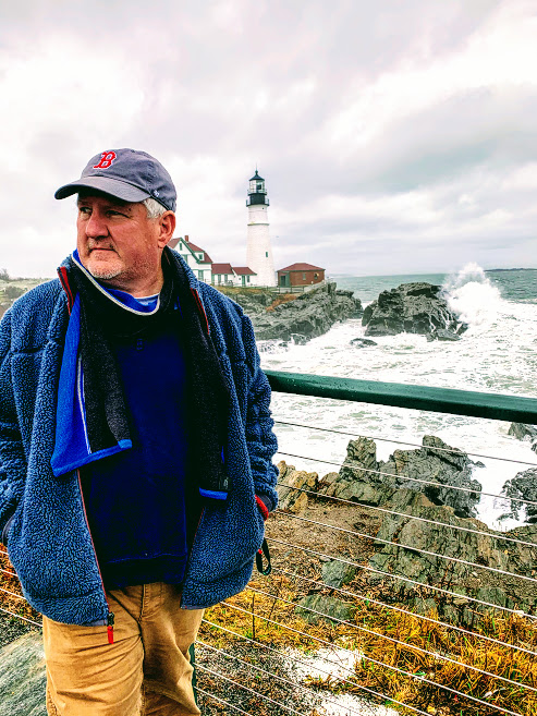 a man standing next to a body of water
