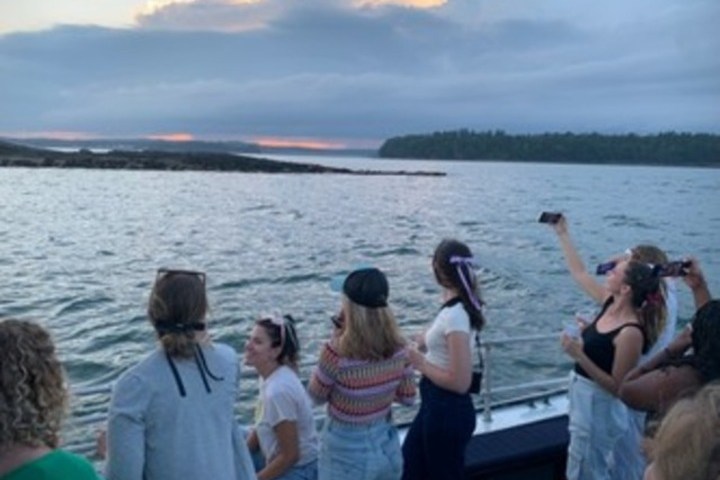a group of people standing next to a body of water