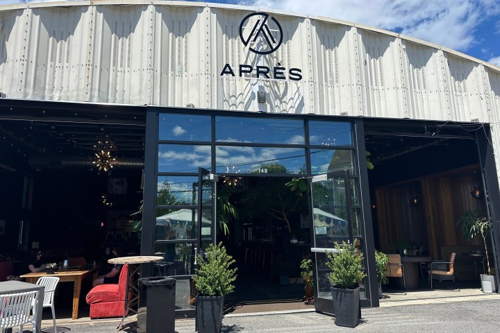 Outdoor view of a restaurant with open doors and 'Après' sign on top.